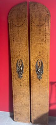 two wooden doors that are next to a red wall