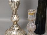 trois bougeoirs en argent posés les uns à côté des autres sur une table