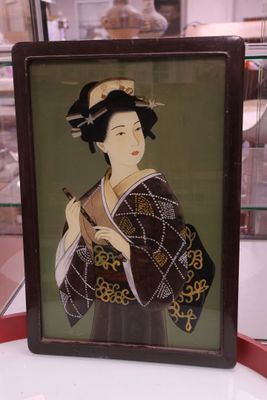 une photo d'une femme en kimono exposée dans une vitrine