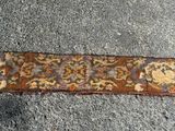 Le tapis posé au sol est marron et présente un motif floral.