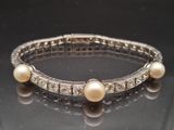 an image of a bracelet with pearls and diamonds on a table