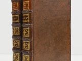 deux vieux livres posés l'un sur l'autre sur une surface blanche