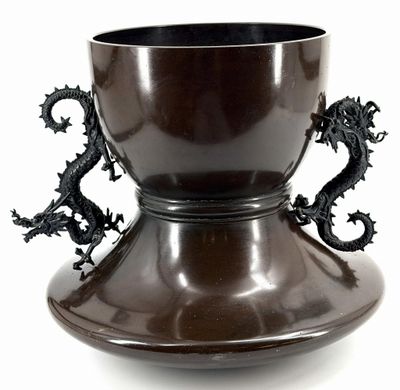 a brown vase with two dragon handles on it