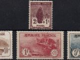 four different stamps of different colors on a black surface