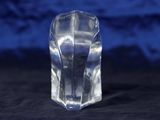 a clear glass block sitting on a black surface