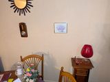 une salle à manger avec une table, des chaises et une horloge accrochée au mur