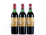 three bottles of red wine sitting next to each other on a white surface