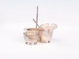 deux tasses en argent posées l'une à côté de l'autre sur une surface blanche