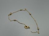 un bracelet en chaîne d'or orné d'un petit pendentif en forme d'œil maléfique