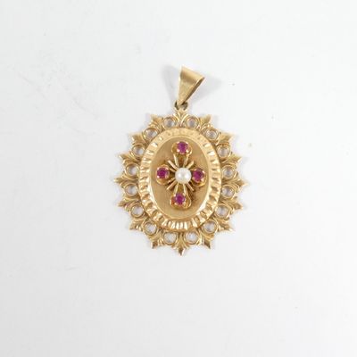 un gros plan d'un pendentif en or orné d'une pierre rose au centre