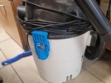 un aspirateur posé sur le sol à côté d'une poubelle