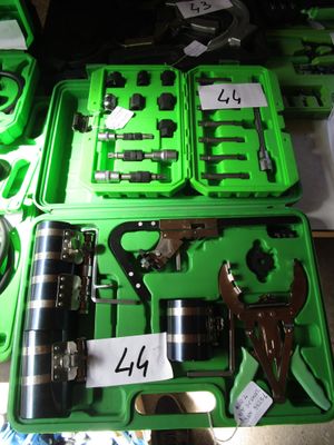 de nombreux outils divers rangés dans une mallette verte posée sur une table