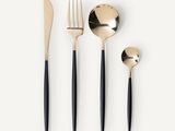 un service de couverts noir et or comprenant une cuillère, une fourchette et un repose-cuillère