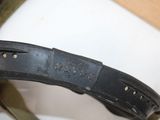 a person holding a leather belt with holes in it