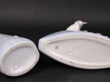 pair of porcelain figurines of a bird on a branch and a bird on a branch