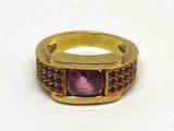 bague plaquée or ornée d'une pierre violette au centre