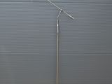 un lampadaire argenté surmonté d'un abat-jour blanc