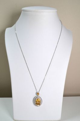 yellow and white necklace on a white mannequin with a gold and silver pendant