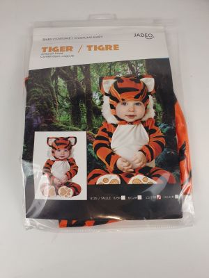 a close up of a baby in a tiger costume on a white surface