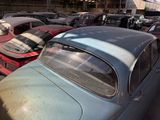 a lot of old cars in a garage with a lot of rust