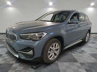 the bmw x1 is parked in a garage with a checkered floor