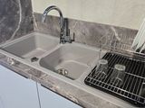 a kitchen sink with a drainer and a grid over it