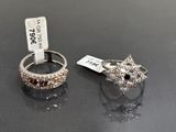 paire de bagues en argent ornées de diamants bruns et blancs sur un fond noir