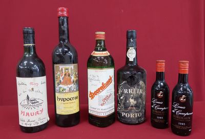 several bottles of wine are lined up on a red surface