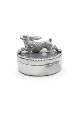 une boîte en argent sur laquelle est représenté un chien