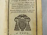 un livre ouvert sur lequel figure un blason