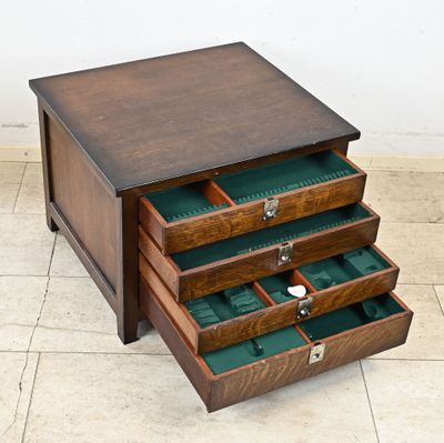 a small wooden table with three drawers on it