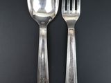 two spoons and a fork on a black table