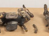 two figurines of a cow and a man riding a horse