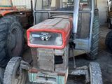 un tracteur garé dans une grange avec d'autres tracteurs
