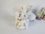 two figurines that are sitting on a white table