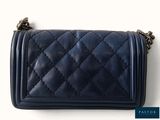 the small blue purse is sitting on a white surface