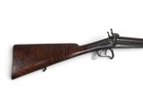 un vieux fusil avec une poignée en bois sur fond blanc