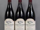 three bottles of wine are lined up on a table