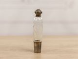 small glass bottle with a metal stopper on a wooden table