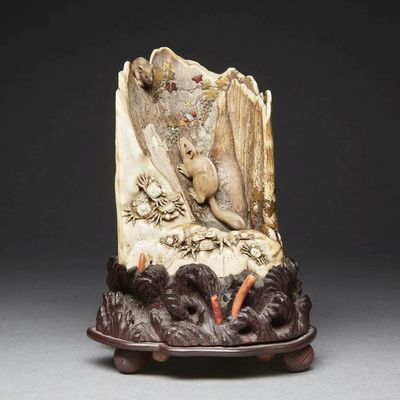 carved ivory figurine of a woman and a bird on a rock