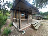 a small wooden house with a porch and a covered porch