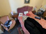 un lit et une chaise dans une chambre avec un couvre-lit rose