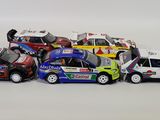 several toy cars are lined up in a row on a white surface
