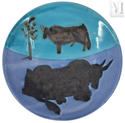 a plate with a picture of a cow and a tree on it