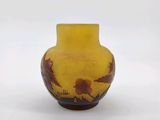 a small yellow vase with a bird design on it