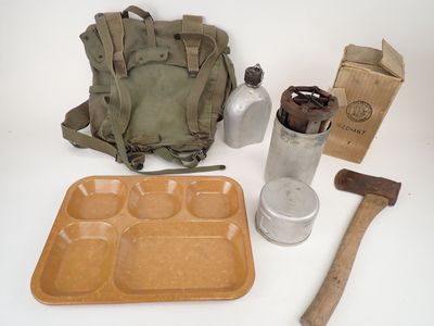 de nombreux objets posés sur la table, notamment un sac à dos, un couteau et une bouteille
