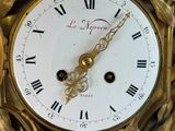 a gold clock with roman numerals on the face of it