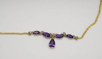 un collier composé de pierres violettes et de chaînes dorées sur un fond blanc