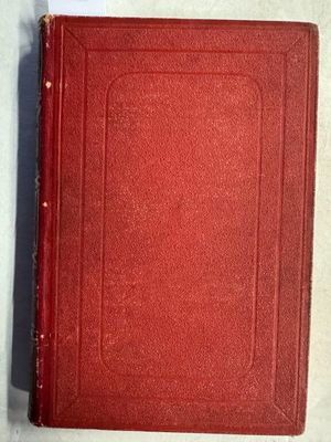 un livre rouge posé sur une table blanche