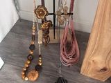 many necklaces and earrings hanging on a rack on the floor